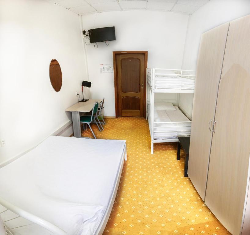 モスクワにあるComfort Park Hostelのベッドとデスクが備わる小さな客室です。