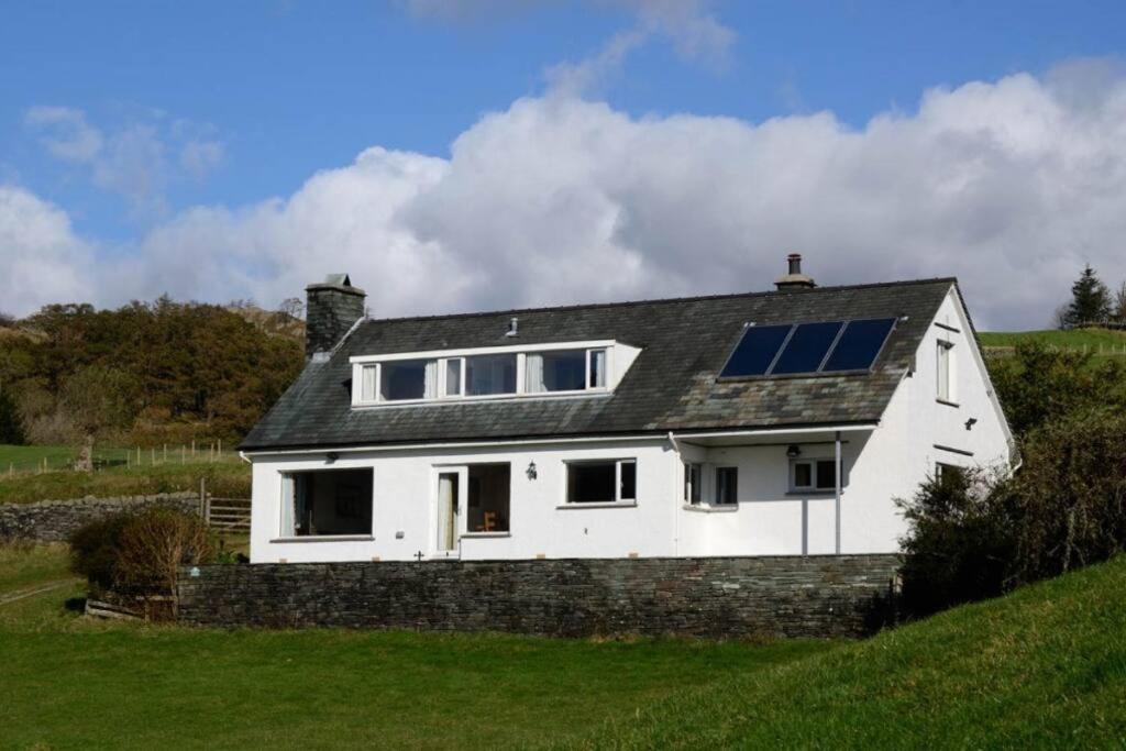 a white house with solar panels on the roof at Lang Parrock, Little Langdale in Little Langdale