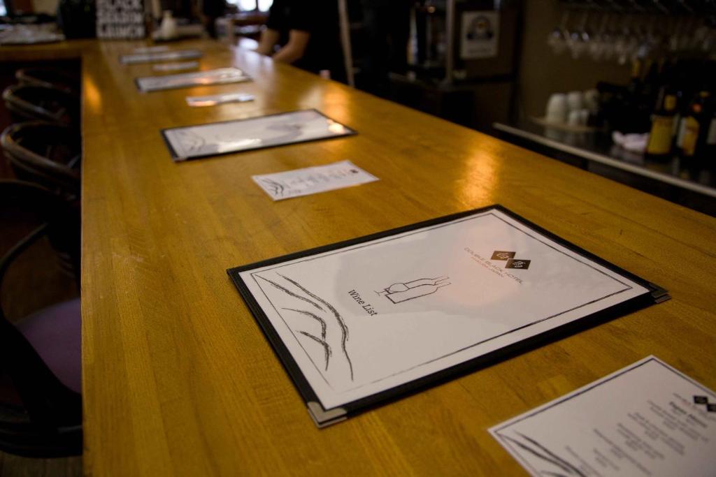a wooden bar with cards on a wooden table at Double Black Hotel in Hakuba