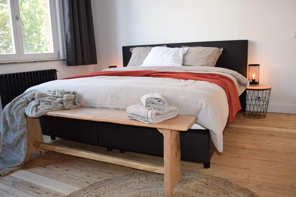 een slaapkamer met een groot bed en handdoeken op een tafel bij Huyze Malou in Ieper