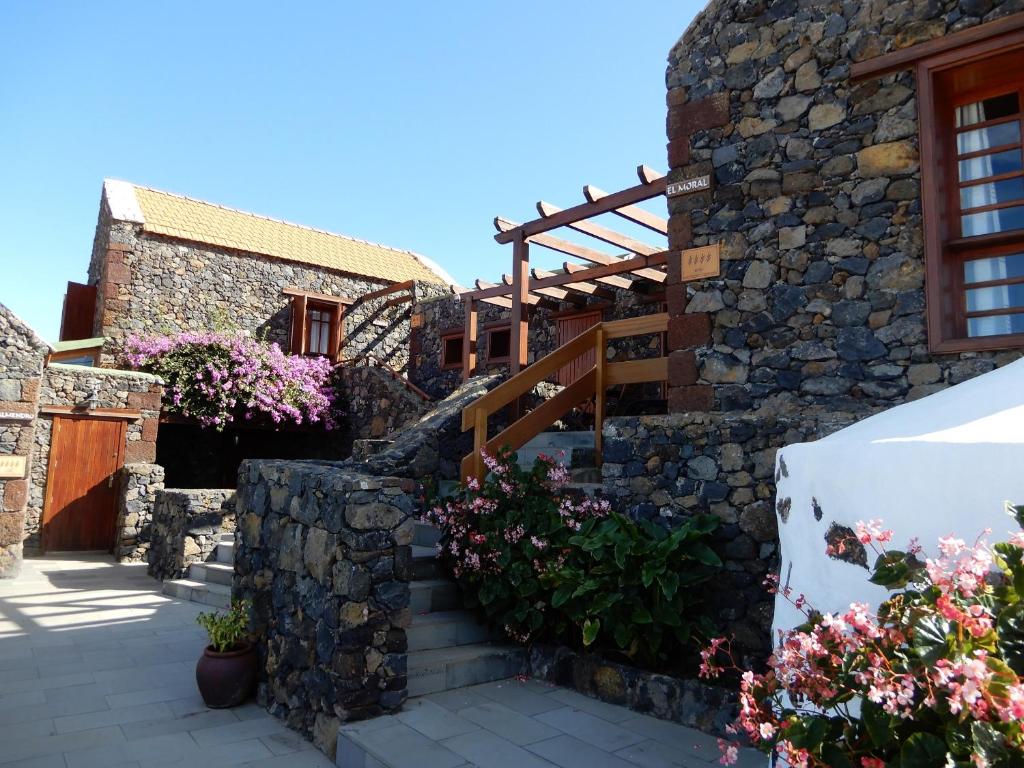 una casa con una pared de piedra y escaleras en Casas Rurales Los Almendreros, en Valverde