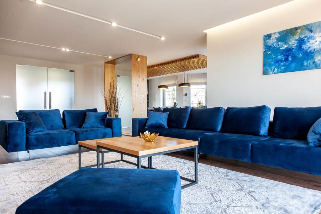 uma sala de estar com sofás azuis e uma mesa em Willa pod Lanckoroną em Izdebnik
