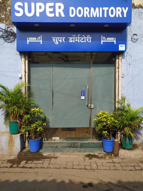 a store with potted plants in front of a door at Super Dormitory AC DELUXE in Mumbai