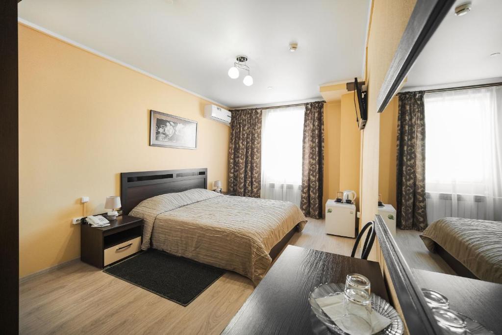 a hotel room with a bed and a table at Hotel Continent in Tobolsk