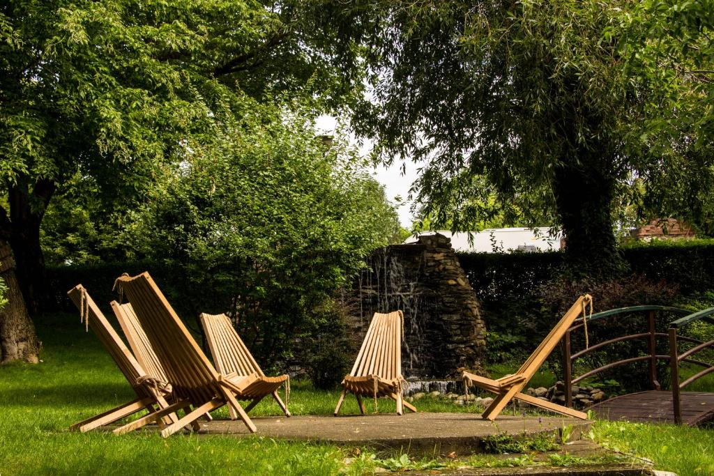 a group of lawn chairs sitting in the grass at Caro Hotel in Bucharest