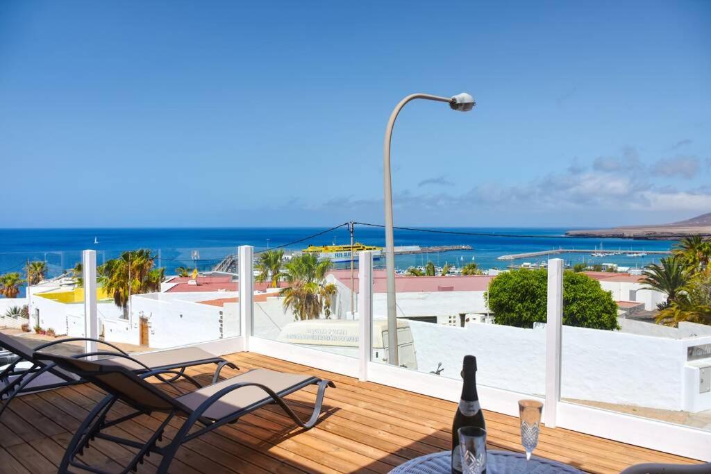 a deck with chairs and a view of the ocean at Casas Pedro & Agata in Morro del Jable