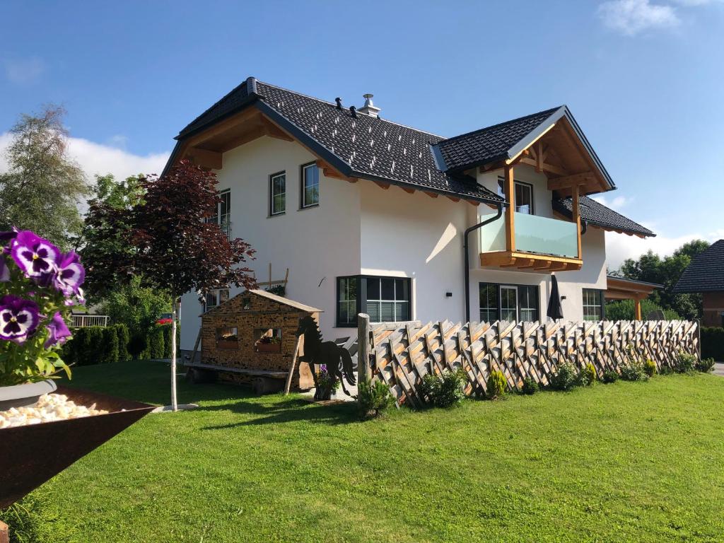 una casa con una valla de madera en el patio en Ferienhaus Wind en Sankt Margarethen im Lungau