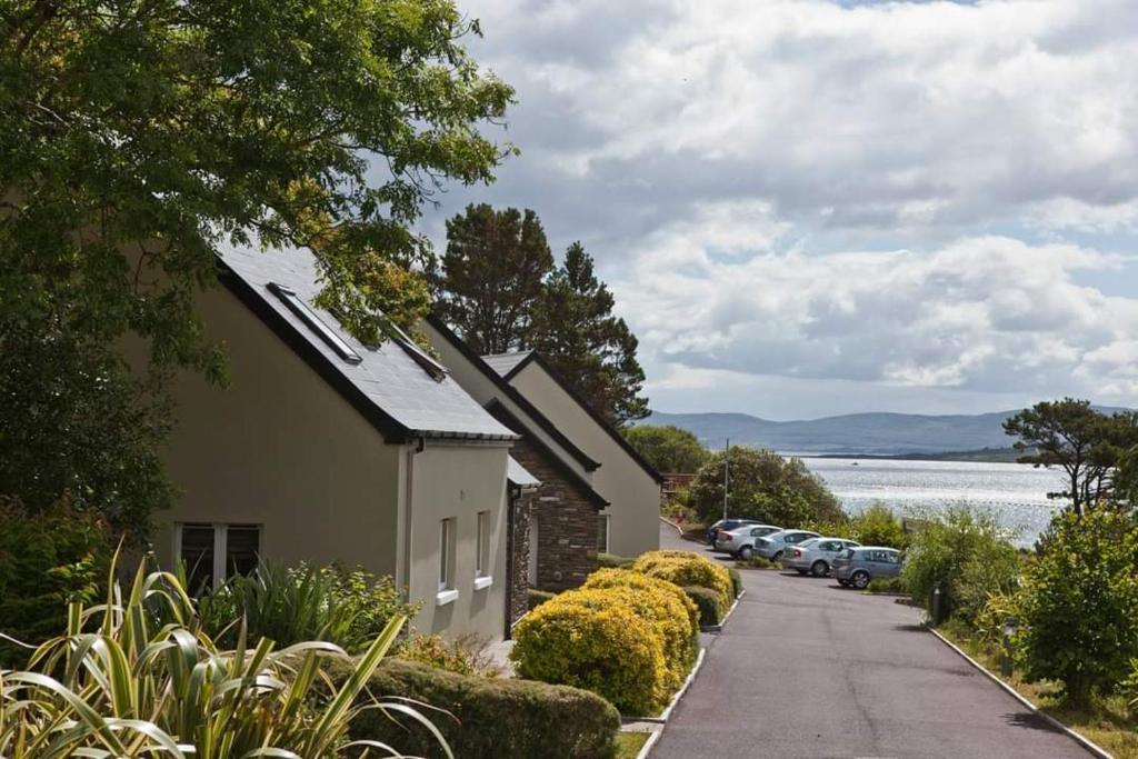 a house with cars parked on the side of a street at Berehaven Lodge in Castletownbere