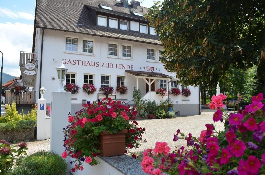 Un bâtiment blanc avec des fleurs devant lui dans l'établissement Hotel Gasthaus Zur Linde, à Glottertal