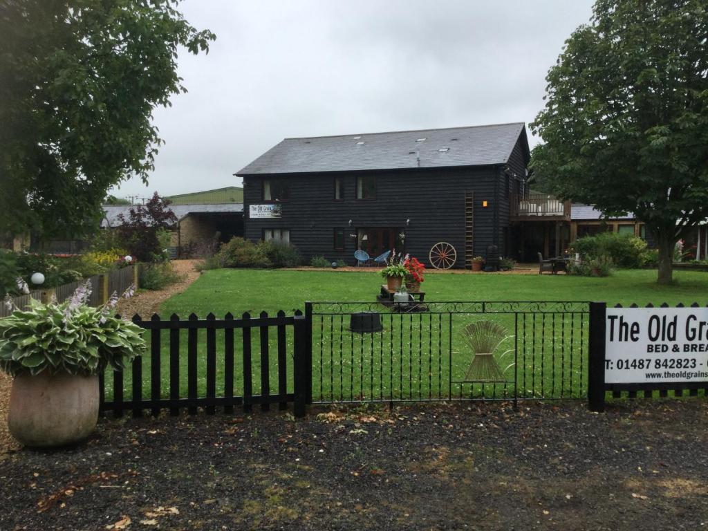 una cerca negra con un cartel delante de una casa en The Old Grain Store Bed & Breakfast, en Pidley