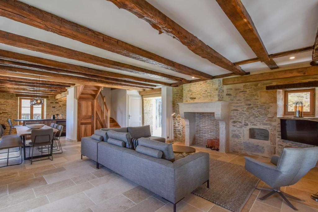 a living room with a couch and a fireplace at Domaine d&#39;Essendiéras in Saint-Médard-dʼExcideuil