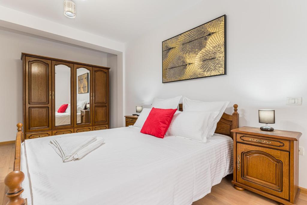 a bedroom with a large white bed with a red pillow at Studio Roberta Coressi in Braşov