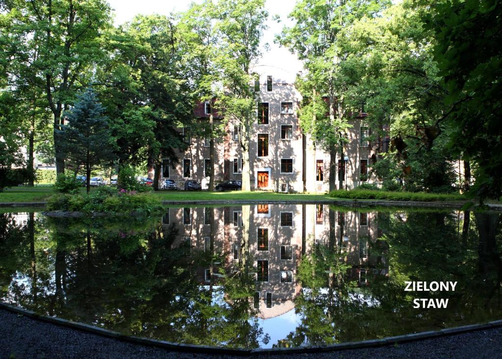 an old building with its reflection in a pond at Muza in Duszniki Zdrój