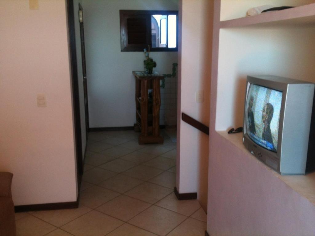 ein Wohnzimmer mit einem TV und einem Aoyer mit einem Flur in der Unterkunft PontaNegra PontadoSolluciene Apartamento aconchegante Oh Vida Boa in Natal
