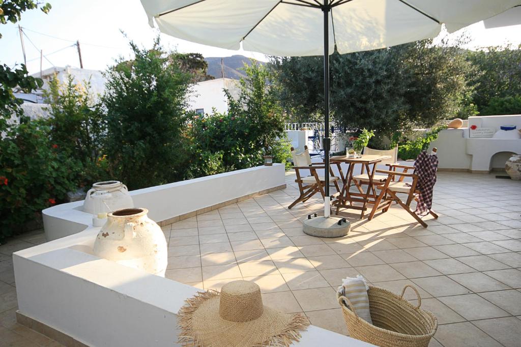 a patio with a table and chairs and an umbrella at Kallichoron Country Houses in Astypalaia Town