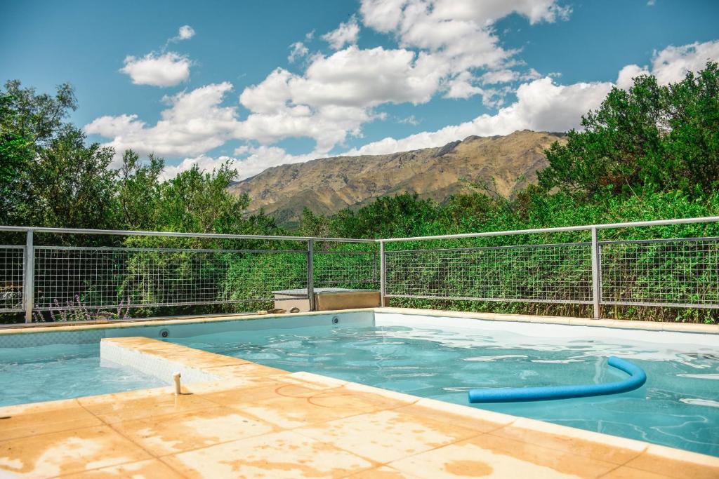 una piscina con montañas en el fondo en Cabaña Negusa en Merlo