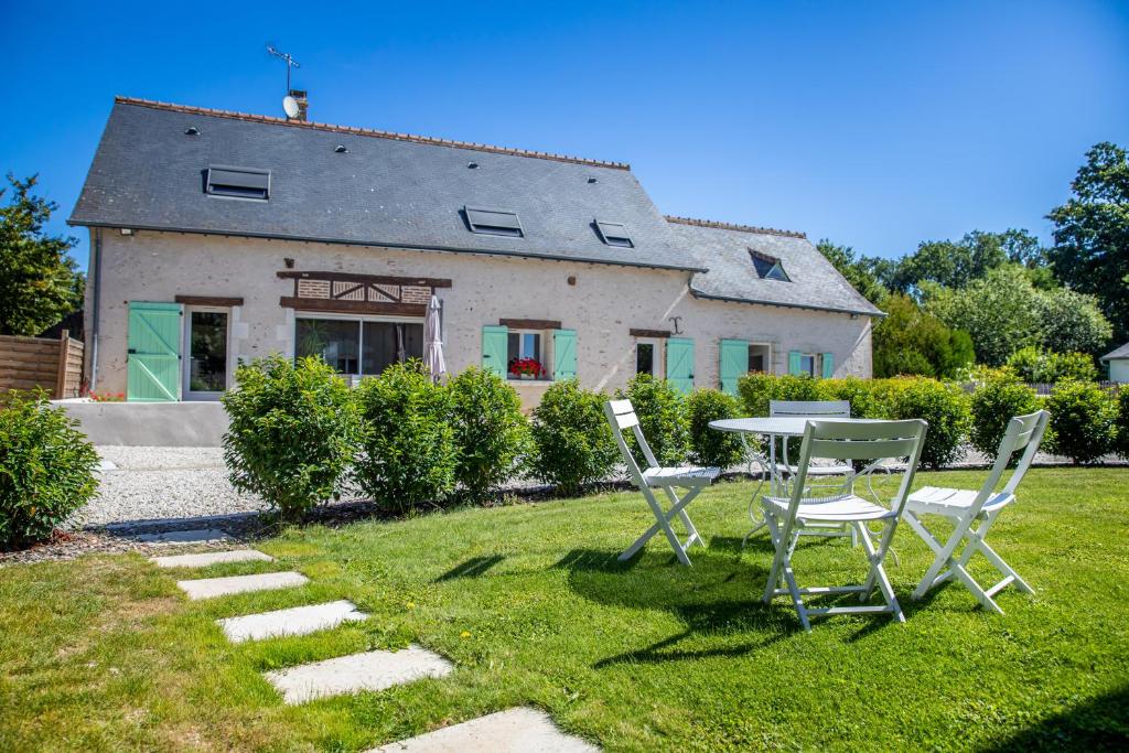 a table and chairs in front of a house at Métairie du Villiers in Saint-Branchs