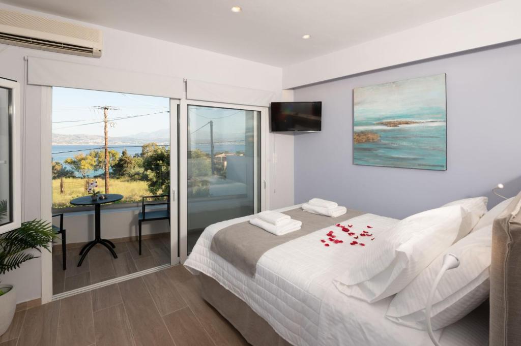 Eleftherias Suites في ماراثي: غرفة نوم مع سرير وإطلالة على المحيط