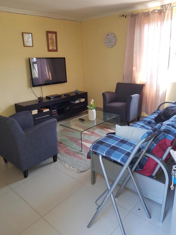 a living room with a couch and a tv at Mary lodge in Cape Town