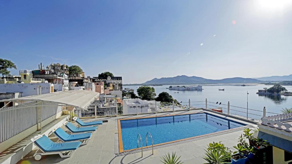 a swimming pool with a view of a body of water at Udaigarh - Udaipur in Udaipur