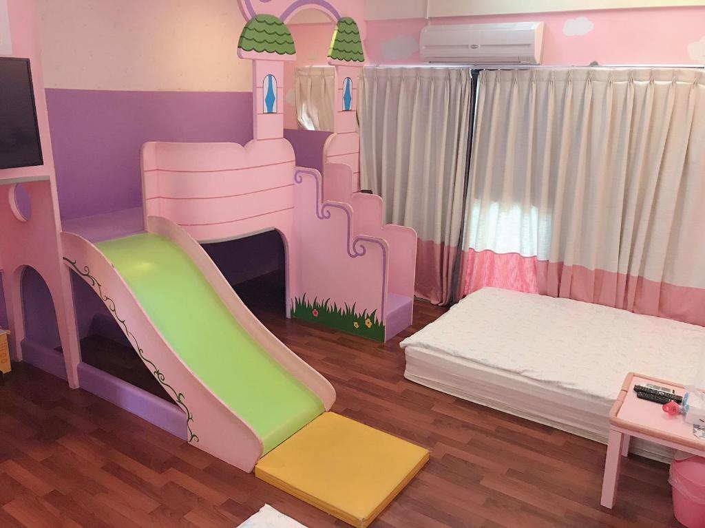 台南的住宿－台南小搗蛋親子民宿，儿童卧室配有粉红色和绿色的双层床