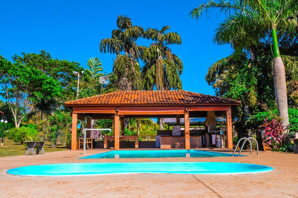 einen Pool mit Pavillon in einem Park in der Unterkunft Pousada 3 Reis in Olímpia
