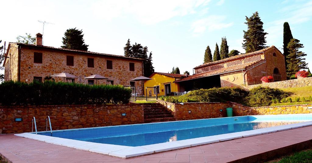 ein Haus mit einem Pool vor einem Gebäude in der Unterkunft Casa Vacanze "L'Aione" in Gambassi Terme