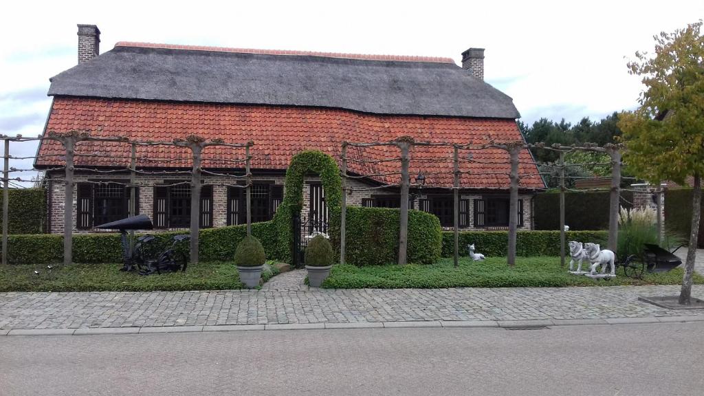 une maison en briques rouges avec un jardin en face de celle-ci dans l'établissement Vakantieverblijf-Beestenboel, à Retie