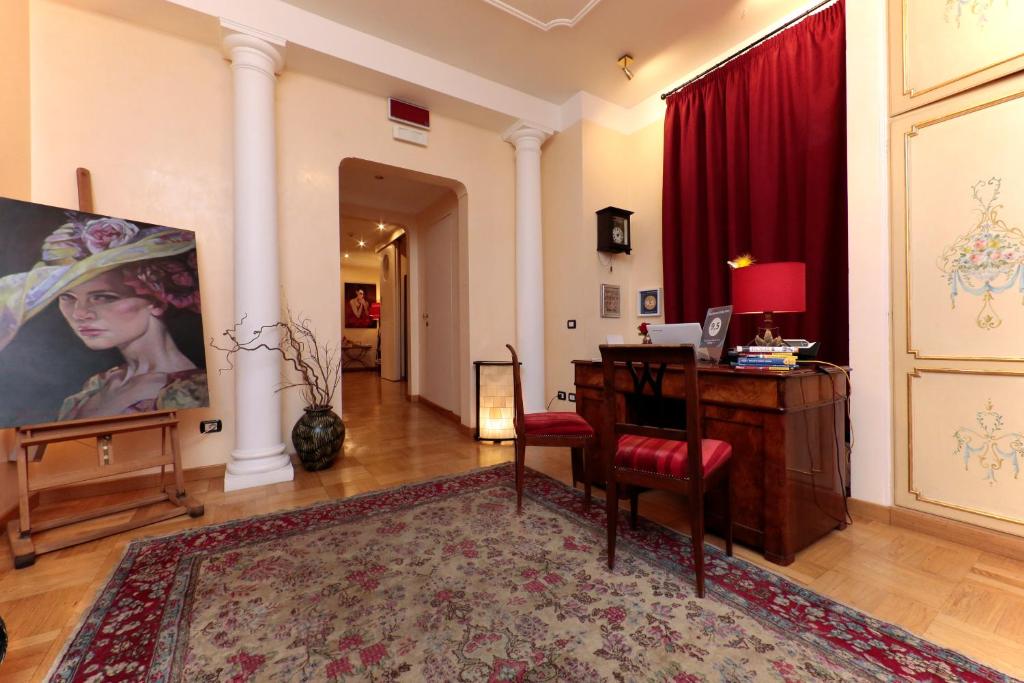 Residenza Delle Arti في روما: غرفة معيشة مع مكتب وستارة حمراء