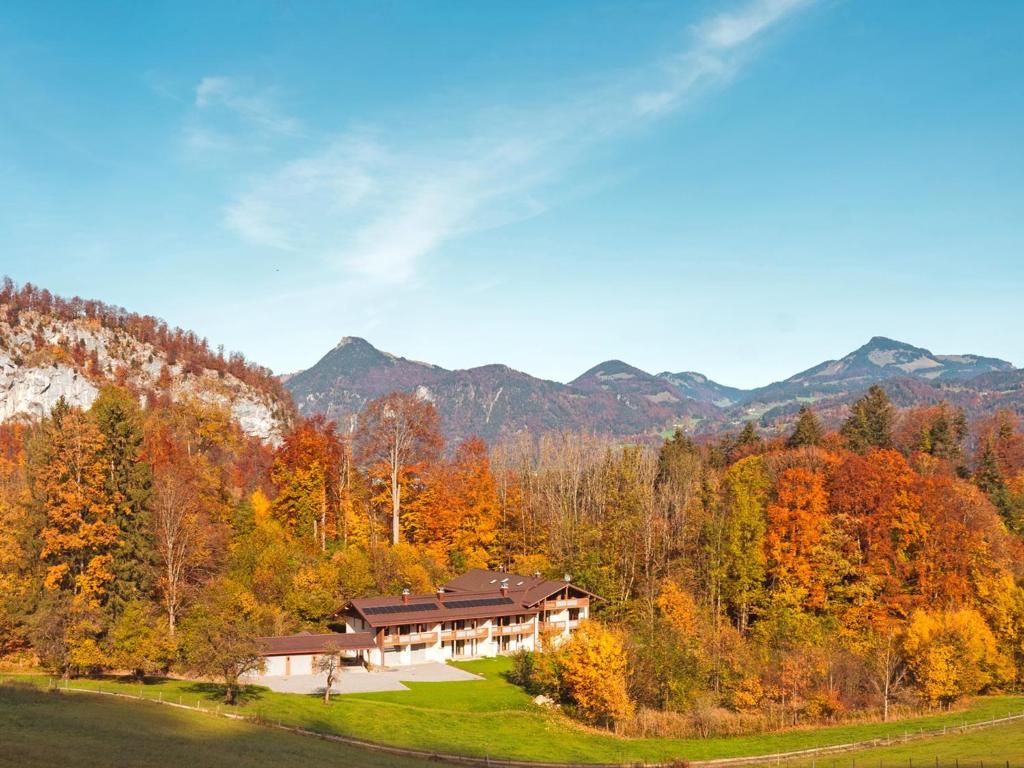 a house in the middle of a forest with mountains at Das Luegstein in Kiefersfelden