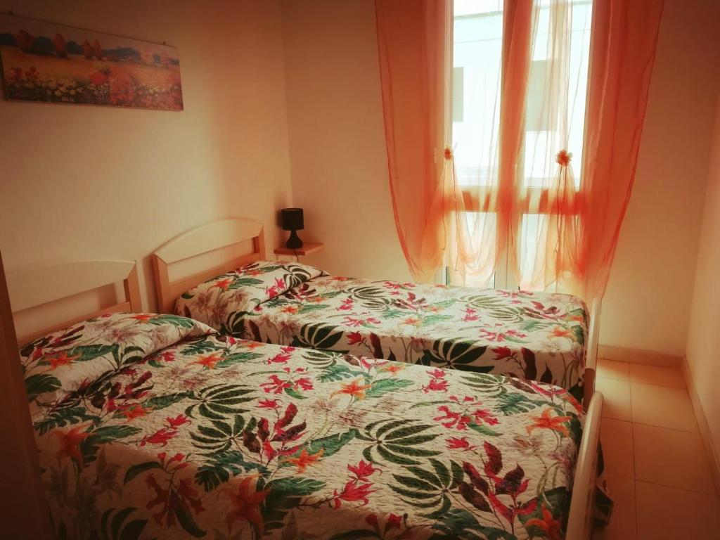 - 2 lits dans une petite chambre avec fenêtre dans l'établissement Case in Residence Torre dell'Orso, à Torre dell'Orso