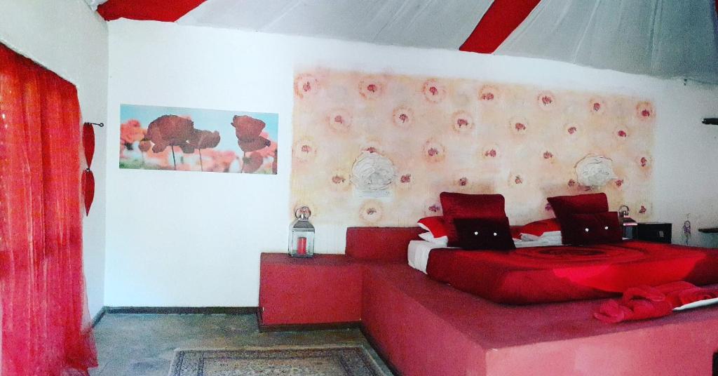 VeraniにあるGecko Nature Lodge Home of Swahili Divers the BEST dive center and Famous Gecko Restaurantの赤いベッド1台(ノートパソコン2台付)が備わるベッドルーム1室が備わります。