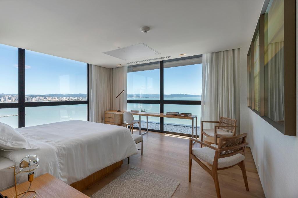 a bedroom with a bed and a view of the ocean at LK Design Hotel Florianópolis in Florianópolis