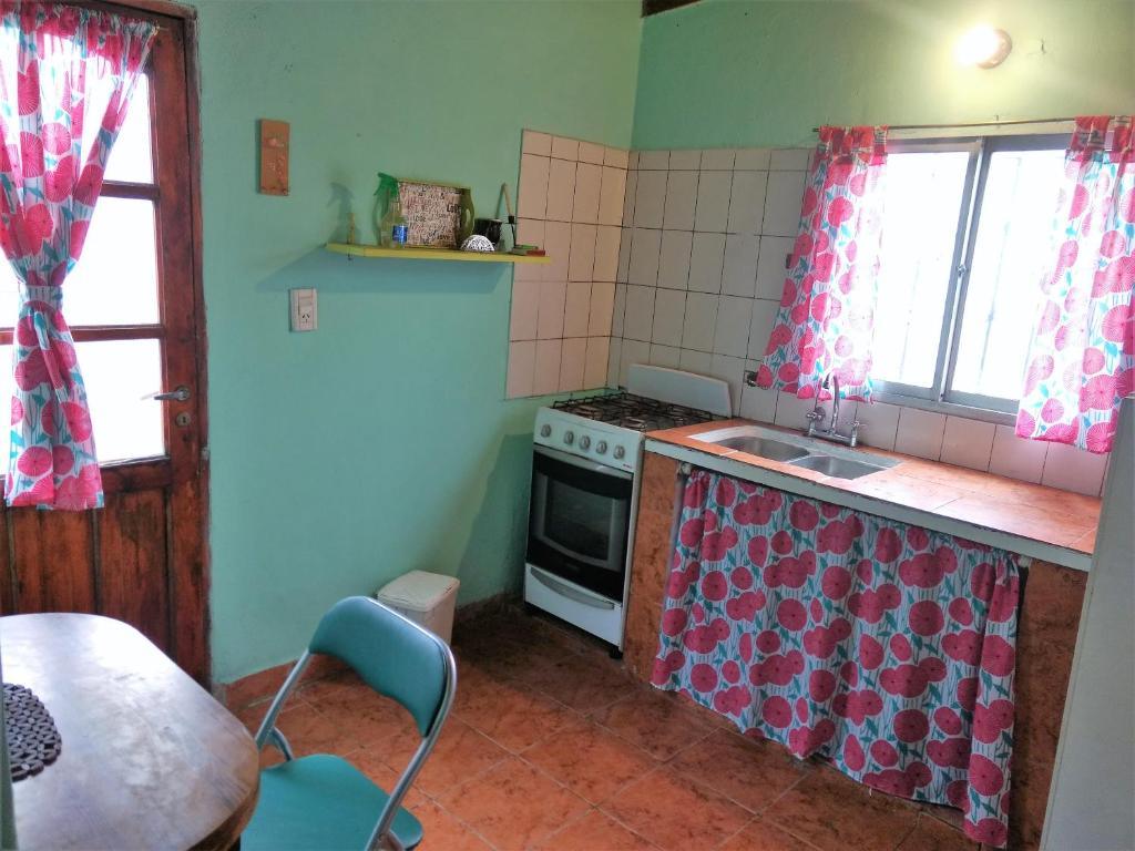 Il comprend une cuisine équipée d'une cuisinière, d'un évier et d'une table. dans l'établissement Posada "Doña Lucia" Para 3 Personas COCHERA PRIVADA GRATIS, à Mar del Plata