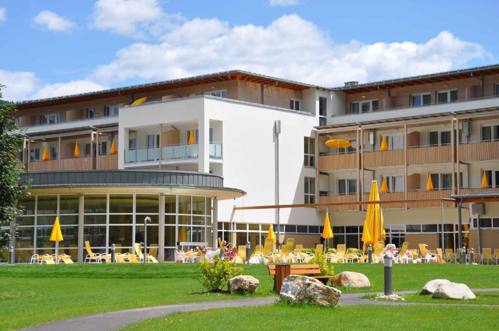 a building with tables and umbrellas in front of it at Gesundheitsresort Bad St. Leonhard in Bad Sankt Leonhard im Lavanttal