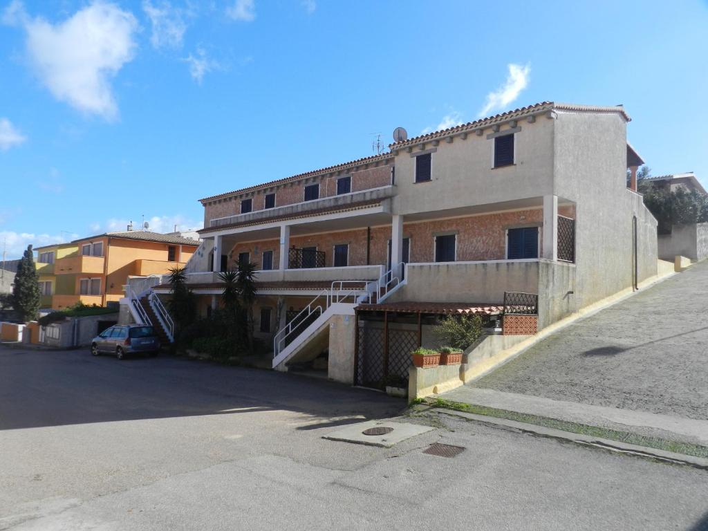 a building with a parking lot in front of it at La Casa Di Babbai Al Mare in Porto Pozzo