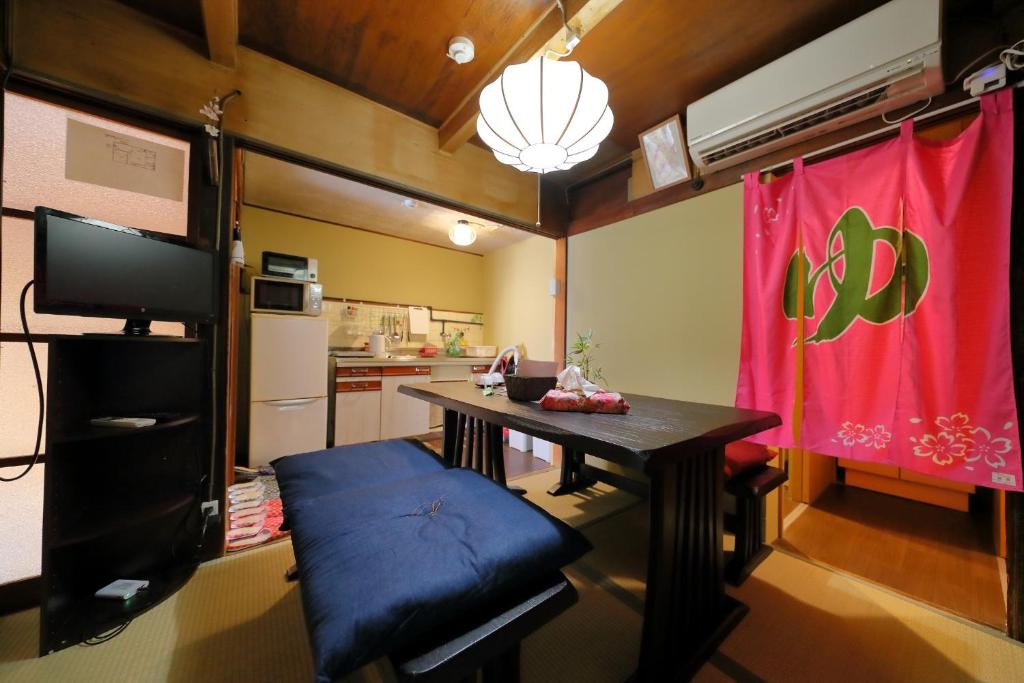 a living room with a table and a red curtain at Oyado Sanjyo-Machiya - Vacation STAY 96740 in Kyoto