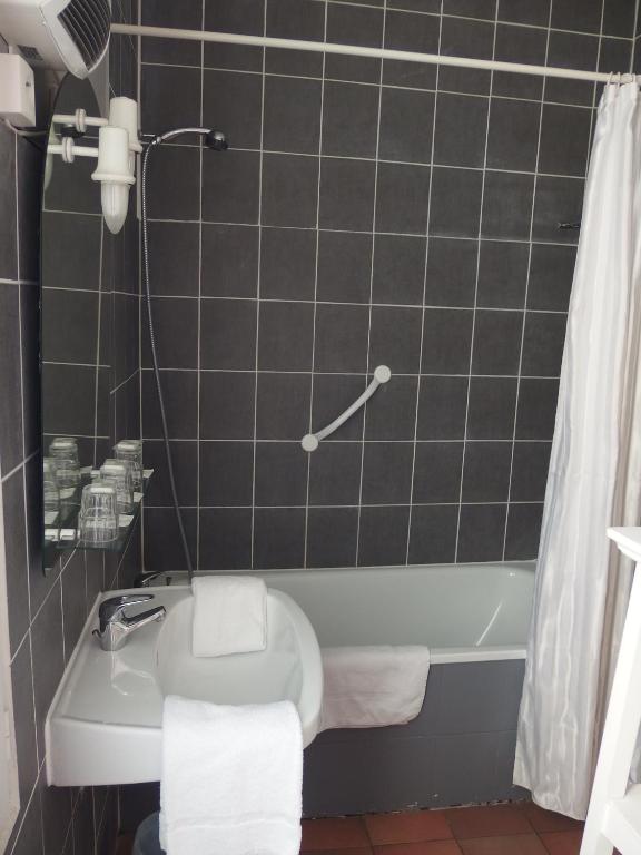 a bathroom with a toilet and a bath tub at Au Saint Roch - Hôtel et Jardin in Avignon