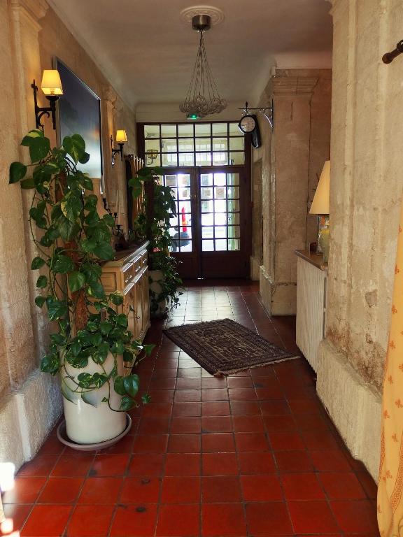 a hallway with plants and a door in a house at Au Saint Roch - Hôtel et Jardin in Avignon