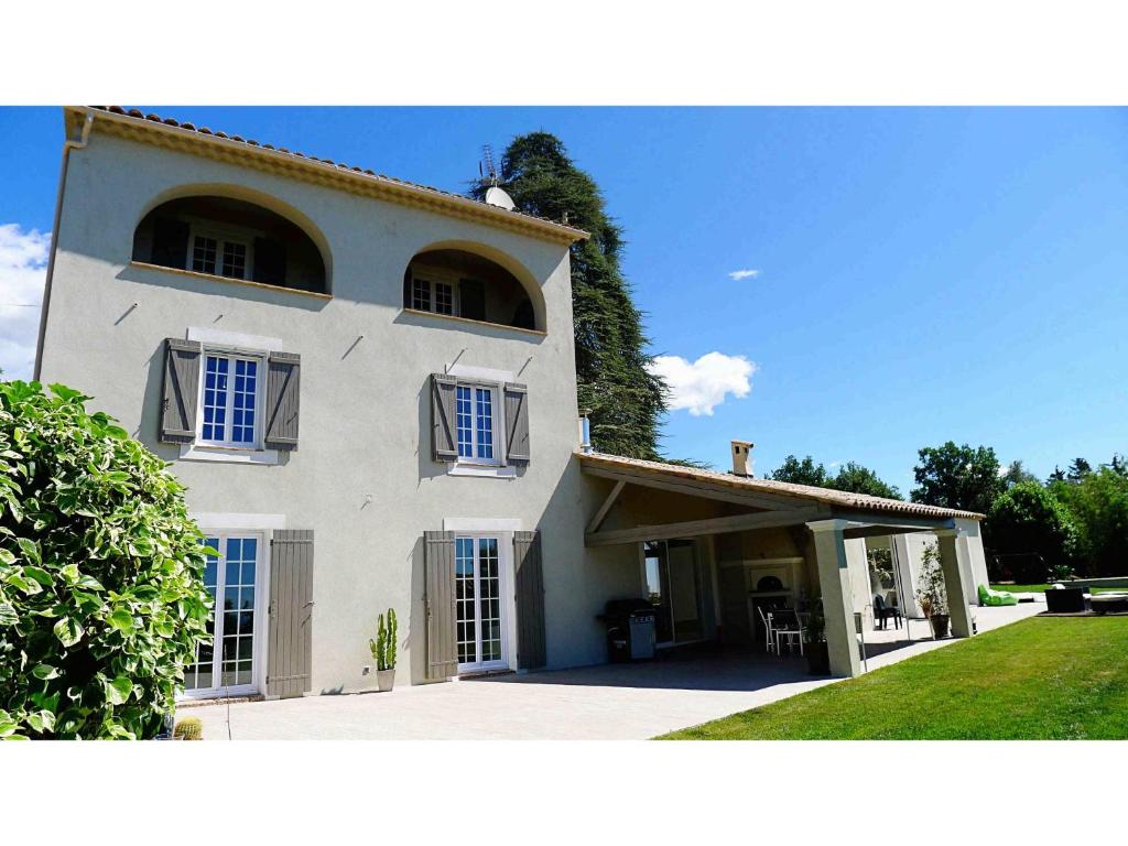 una grande casa bianca con finestre blu e un cortile di Le clos des anges - Riviera Cote d'Azur - La Gaude a La Gaude
