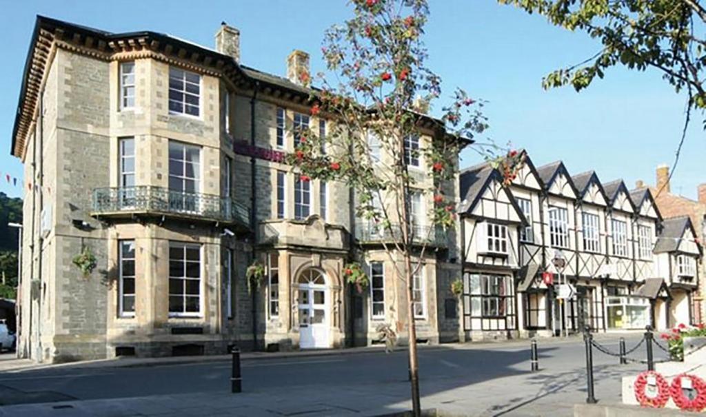 a large stone building on a street at The Knighton Hotel in Knighton