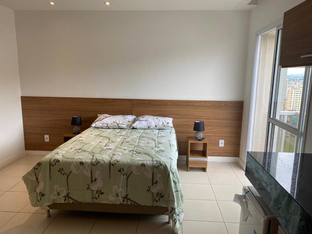 um quarto com uma cama e uma grande janela em Hotel Mont Blanc Diamond Flat em Nova Iguaçu