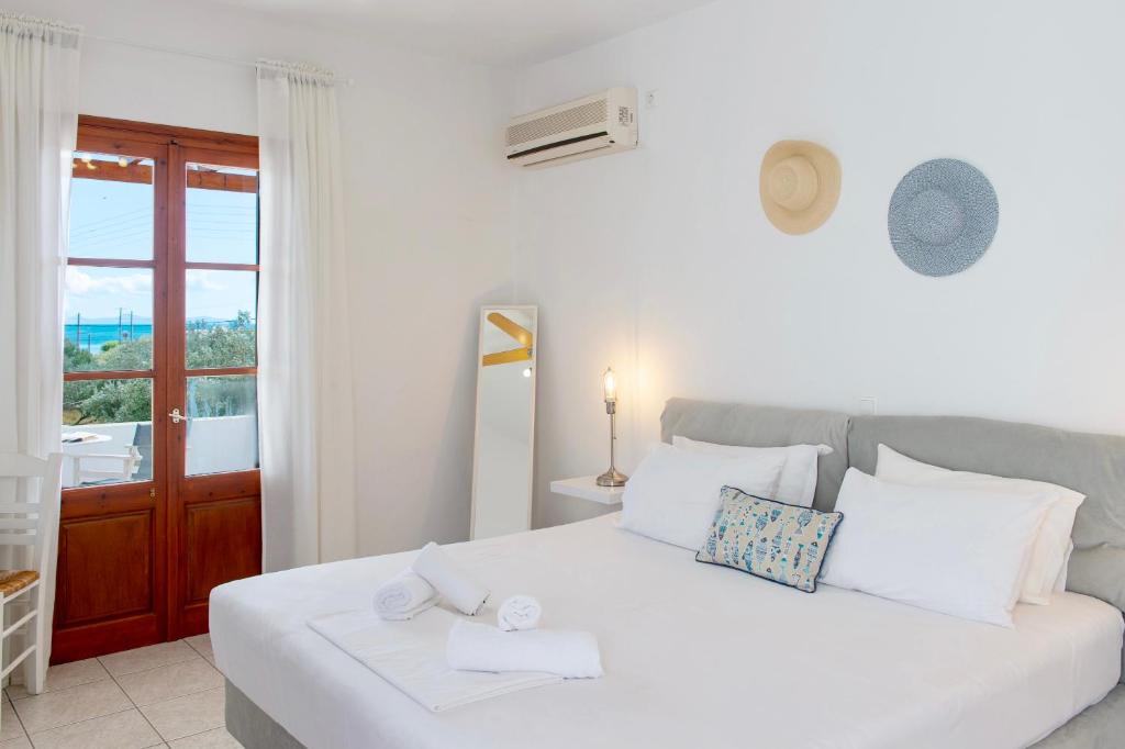 uma cama branca num quarto com uma janela em Blue Fish em Platis Gialos, Sifnos