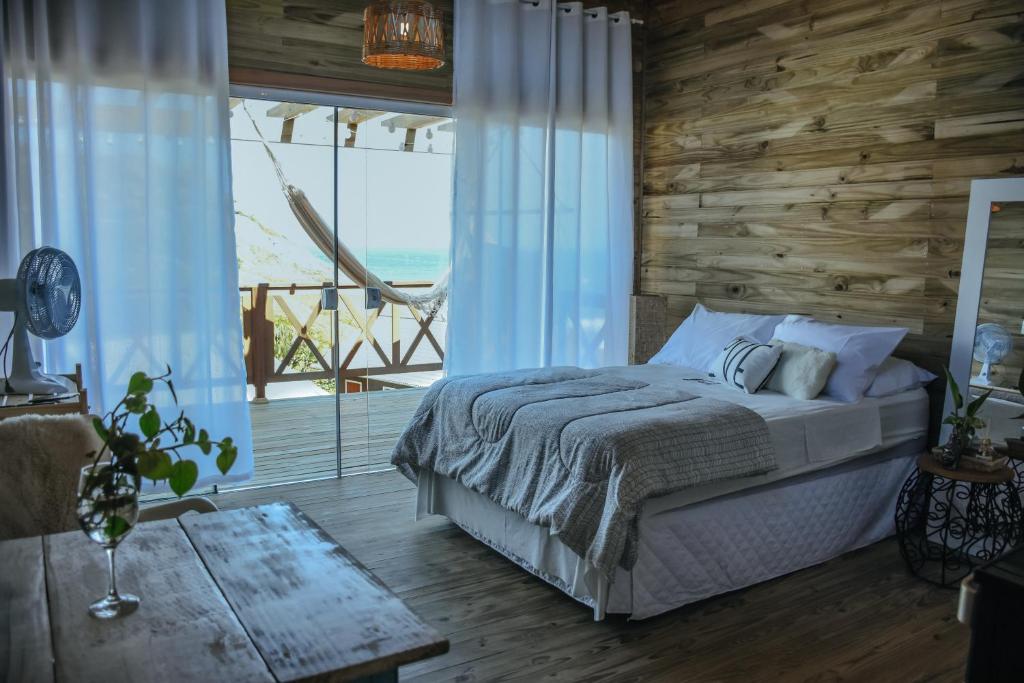 a bedroom with a bed with a view of the ocean at Loft Casa no Farol in Laguna