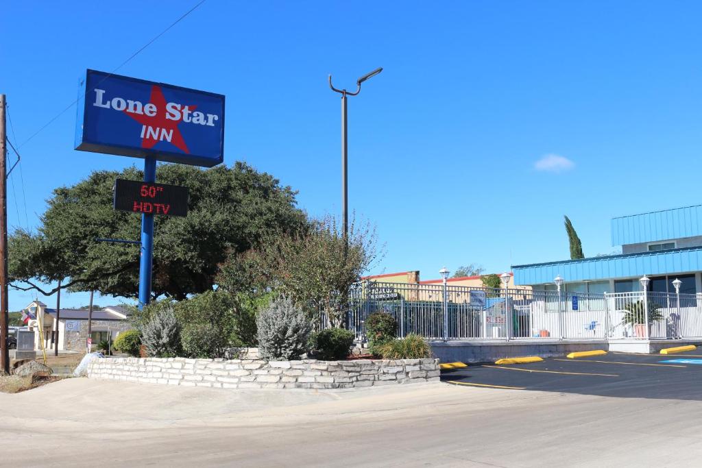 un letrero callejero para una posada estrella solitaria en una calle en Lone Star Inn Kerrville/Fredericksburg, en Kerrville