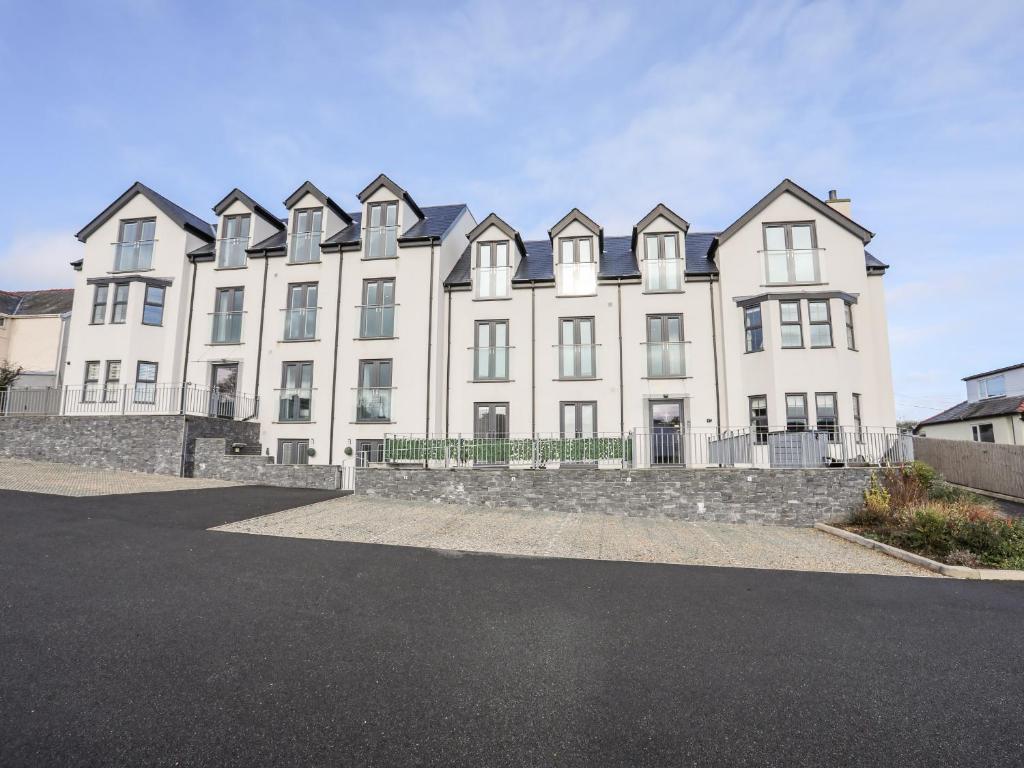 a large white building with black roof at Puffin Pad in Benllech