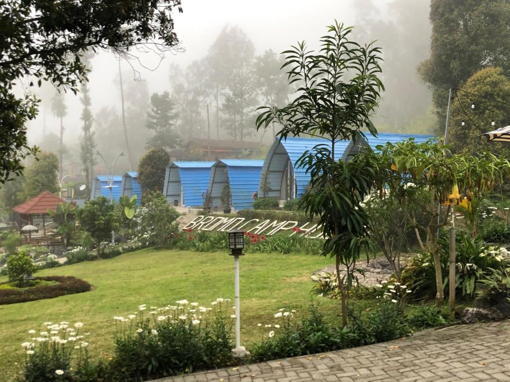a garden with blue houses in the background at Bromo Camp House in Bromo