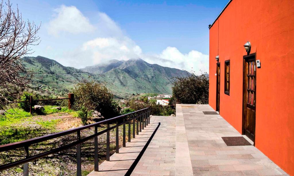 an orange building with a view of a mountain at Albergue de Bolico in Buenavista del Norte