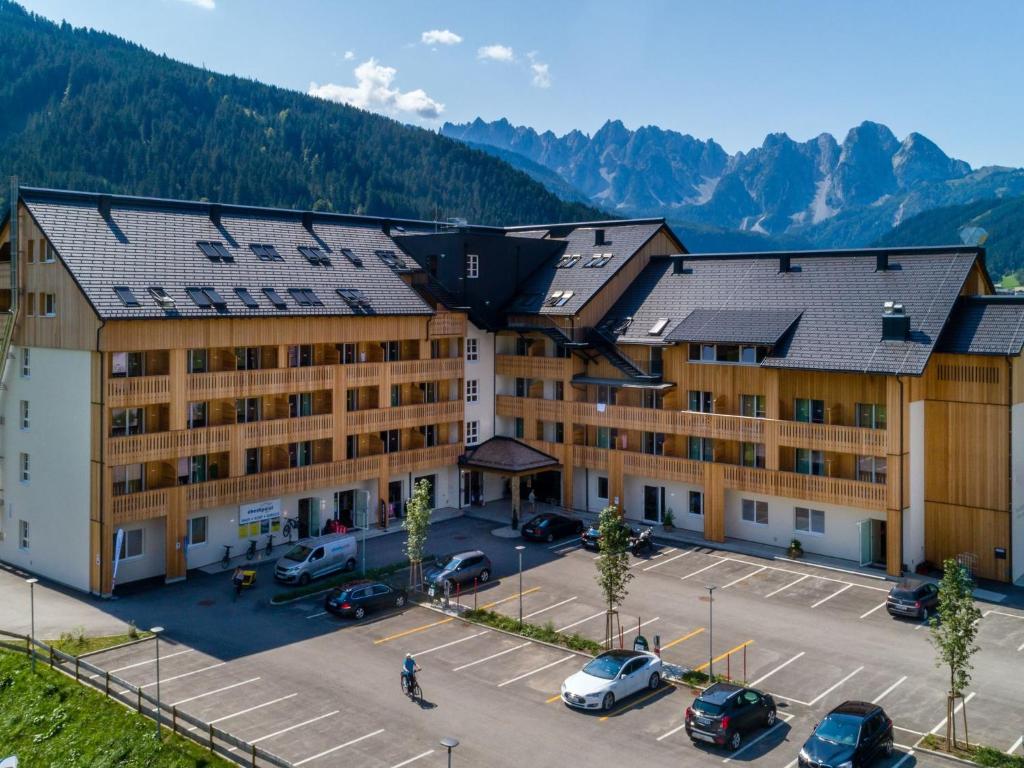 ein großes Gebäude mit Autos auf einem Parkplatz in der Unterkunft Luxurious Apartment in Gosau near Ski Area in Gosau