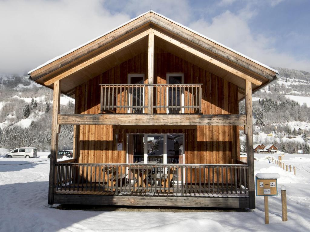 a log cabin with a balcony in the snow at Charming Chalet in Sankt Georgen ob Murau on Ski Slopes in Sankt Lorenzen ob Murau